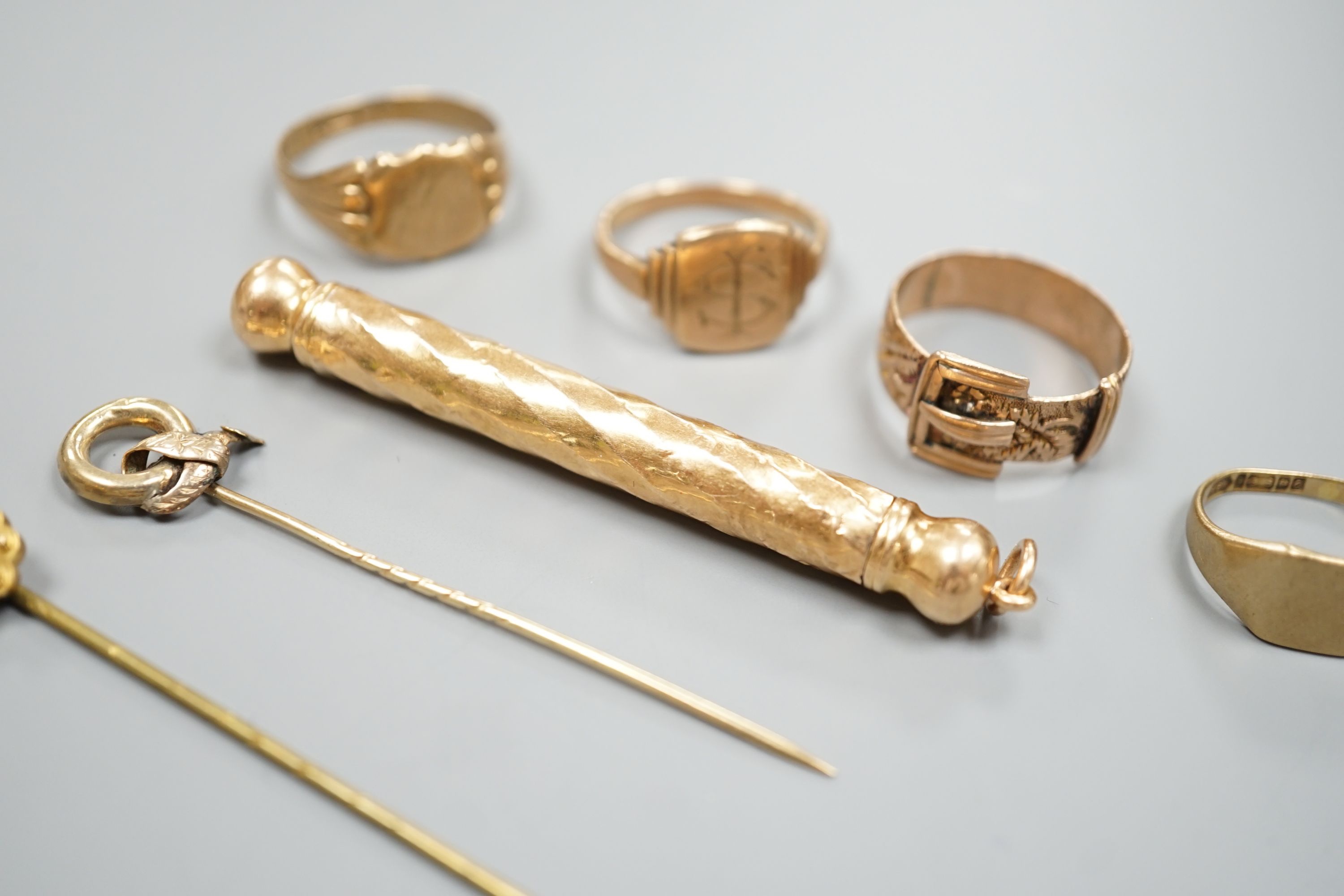 Four assorted 9ct rings including a Victorian buckle ring, 14 grams, two stick pins including part 15ct, a pair of yellow metal ear clips and a yellow metal overlaid propelling pencil.